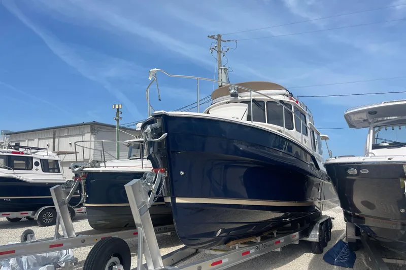 The Image of 2025 Ranger Tugs R-31 CB boat on trailer under clear blue sky. - 0
