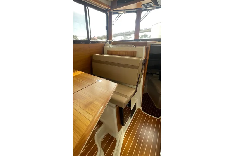 Slide: The Image of 2025 Ranger Tugs R-31 CB interior with wood finish and cushioned seating. - 8