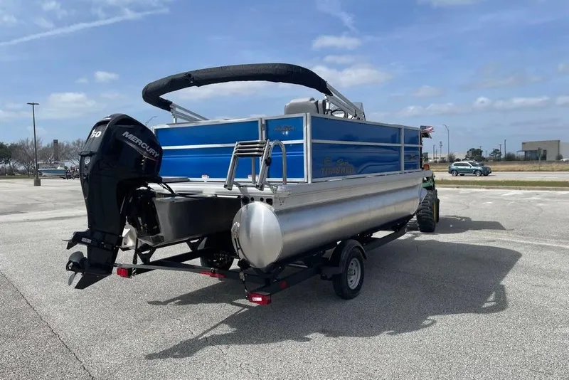 Slide: The Image of 2026 Sun Tracker Party Barge 16 DLX pontoon boat on trailer, parked outdoors. - 1