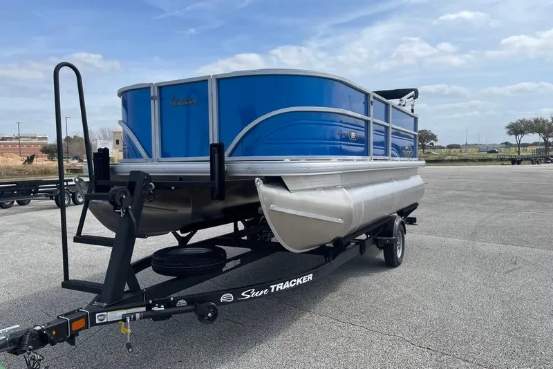 Slide: The Image of 2026 Sun Tracker Party Barge 16 DLX pontoon boat on trailer in parking lot. - 2