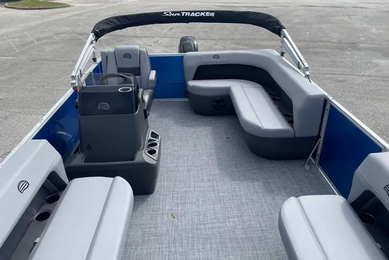 Slide: The Image of 2026 Sun Tracker Party Barge 16 DLX interior with gray seating and blue accents. - 3