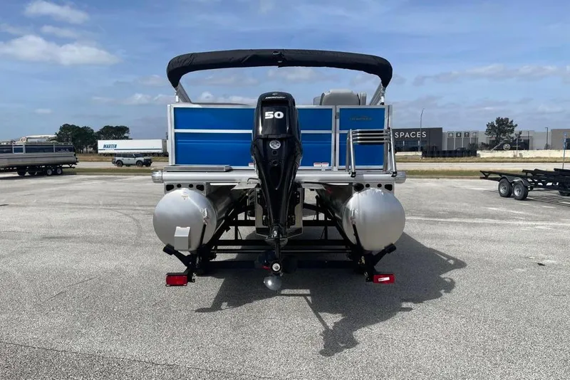 Slide: The Image of 2026 Sun Tracker Party Barge 16 DLX pontoon boat with 50 HP engine, parked outdoors. - 4