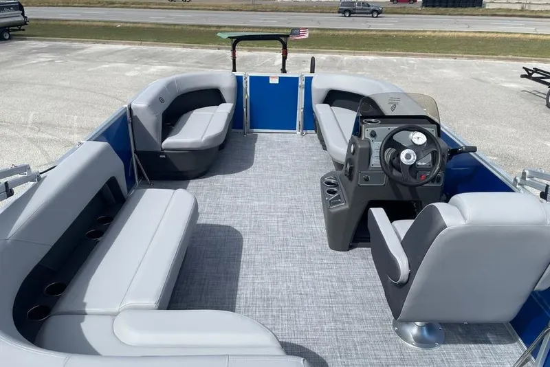 Slide: The Image of 2026 Sun Tracker Party Barge 16 DLX interior with gray seating and steering console. - 7