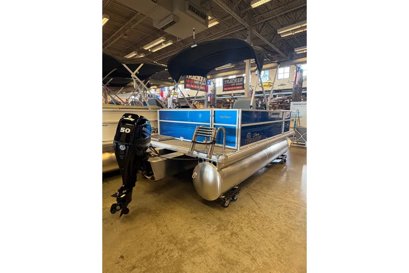 Slide: The Image of 2026 Sun Tracker Party Barge 16 DLX pontoon boat with Mercury outboard motor in showroom. - 70