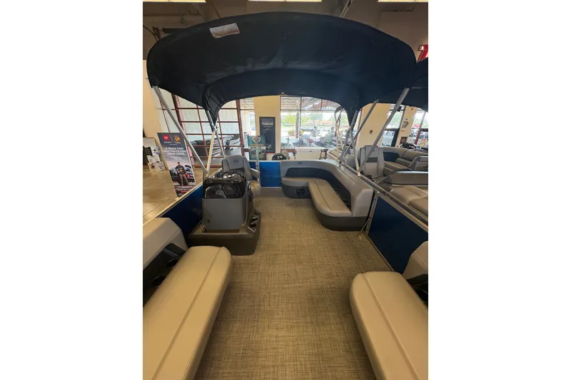 Slide: The Image of 2026 Sun Tracker Party Barge 16 DLX interior with seating and canopy in showroom. - 72