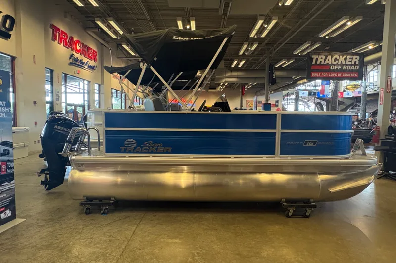 Slide: The Image of 2026 Sun Tracker Party Barge 16 DLX pontoon boat displayed indoors. - 69