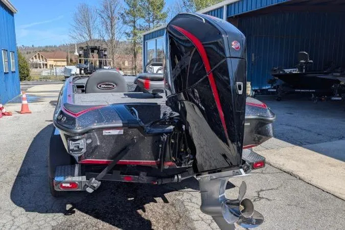 Slide: The Image of 2026 Triton 19 TrX Patriot boat with powerful outboard motor, parked outdoors. - 66