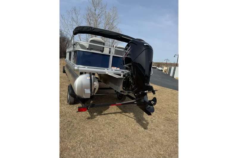 Slide: The Image of 2026 Sun Tracker Bass Buggy 18 DLX pontoon boat with outboard motor on trailer. - 15