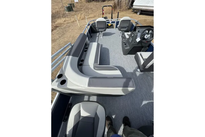 Slide: The Image of 2026 Sun Tracker Bass Buggy 18 DLX pontoon boat interior with seating and steering console. - 4