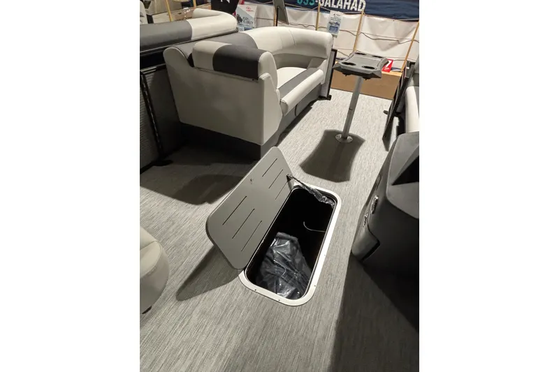 Slide: The Image of 2026 Bennington 22 S Swingback interior with open storage compartment and seating. - 6