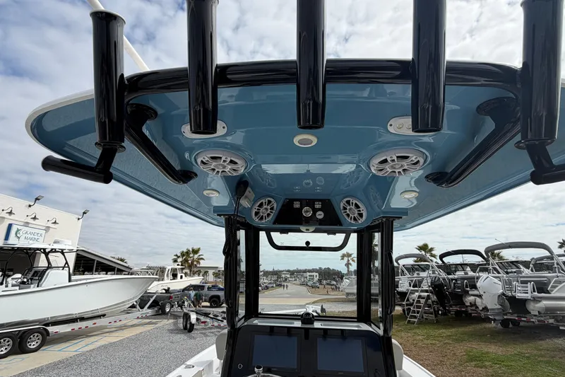 Slide: The Image of 2024 Sportsman Masters 267 Bay Boat with blue T-top and rod holders, docked at marina. - 10