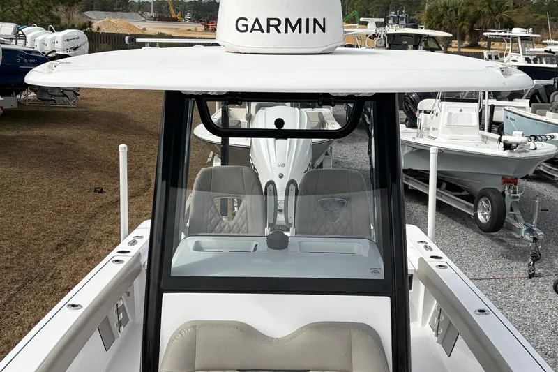 Slide: The Image of 2024 Sportsman Masters 267 Bay Boat with Garmin equipment, docked among other boats. - 11