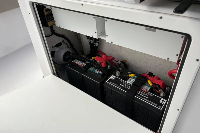 Slide: The Image of 2024 Sportsman Masters 267 Bay Boat battery compartment with dual batteries and wiring. - 19