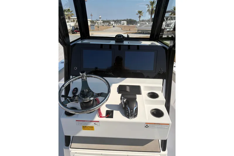 Slide: The Image of 2024 Sportsman Masters 267 Bay Boat dashboard with steering wheel and navigation screens. - 9