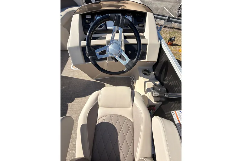 Slide: The Image of 2018 Bennington 23 SSBXP boat interior with steering wheel and beige seating. - 13