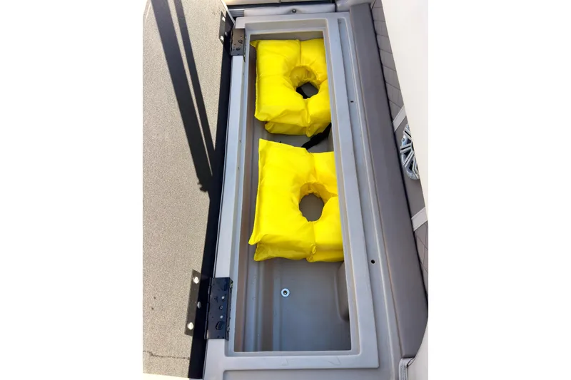 Slide: The Image of Storage compartment with yellow life jackets on a 2018 Bennington 23 SSBXP boat. - 18