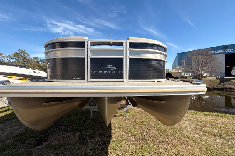 Slide: The Image of 2018 Bennington 23 SSBXP pontoon boat on grass, blue sky background. - 2