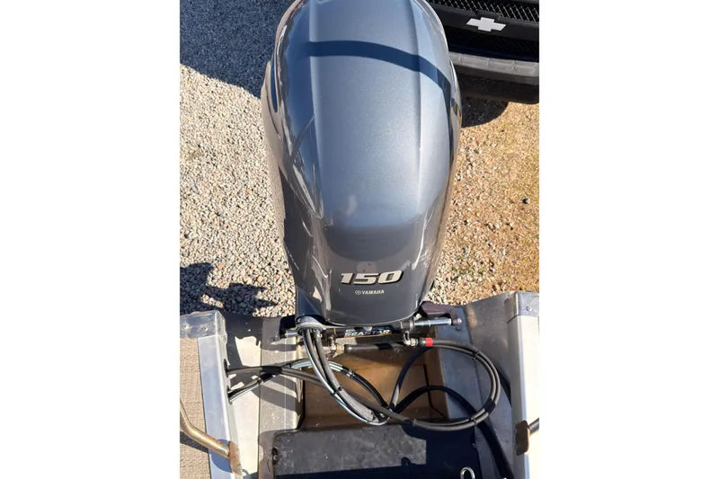 Slide: The Image of 2018 Bennington 23 SSBXP with Yamaha 150 outboard motor, parked on gravel. - 4