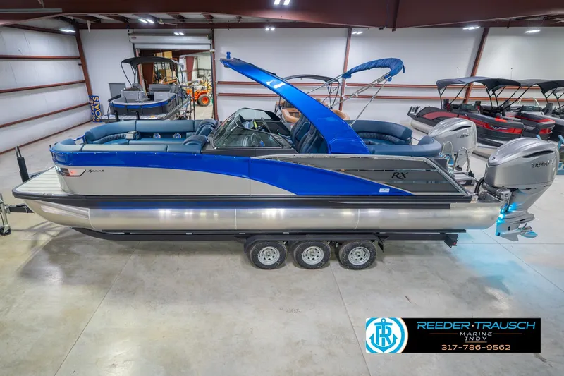 The Image of 2026 Bennington 27 RX pontoon boat in showroom, featuring sleek design and dual outboard motors. - 1