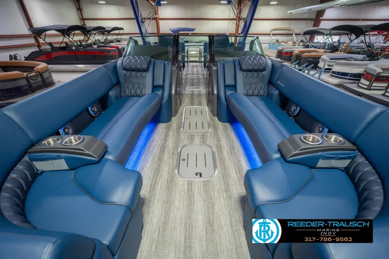 Slide: The Image of 2026 Bennington 27 RX luxury pontoon boat interior with blue seating and cup holders. - 15