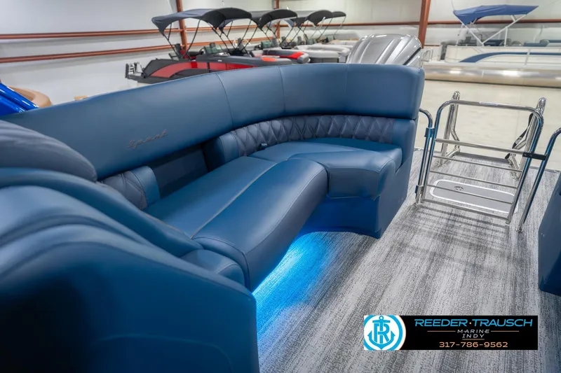 Slide: The Image of 2026 Bennington 27 RX boat interior with blue seating and ambient lighting. - 27