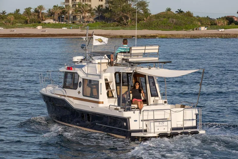Slide: The Image of Manufacturer Provided Image: 2025 Ranger Tugs R-29 CB cruising near a scenic shoreline. - 4