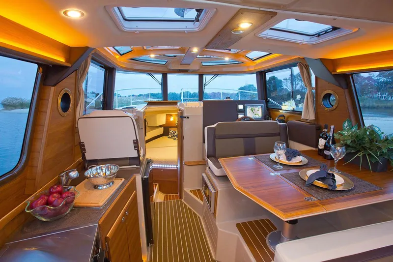 Slide: The Image of Manufacturer Provided Image: Luxurious interior of 2025 Ranger Tugs R-29 CB with elegant dining area and panoramic windows. - 6