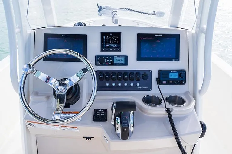 Slide: The Image of Manufacturer Provided Image: 2026 Boston Whaler 220 Dauntless boat dashboard with steering wheel and navigation screens. - 9