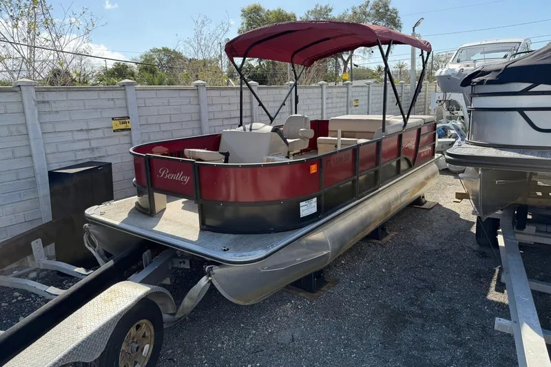 The Image of 2020 Bentley Pontoons 200 Fish boat with red canopy on trailer, parked outdoors. - 0