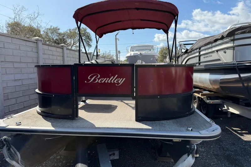 Slide: The Image of 2020 Bentley Pontoons 200 Fish boat with red canopy, parked outdoors. - 2