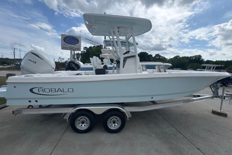 The Image of 2026 Robalo 246 Cayman boat on trailer, side view under cloudy sky. - 0