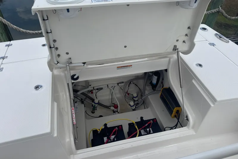 Slide: The Image of Open storage compartment of 2026 Robalo 246 Cayman boat, showing internal components and wiring. - 7