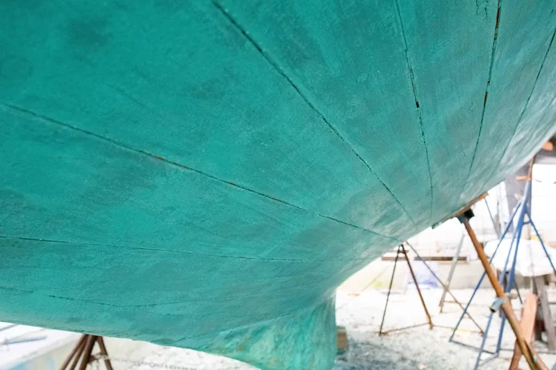 Slide: The Image of Close-up of 1965 Concordia 39 boat hull with teal paint and visible planks. - 12