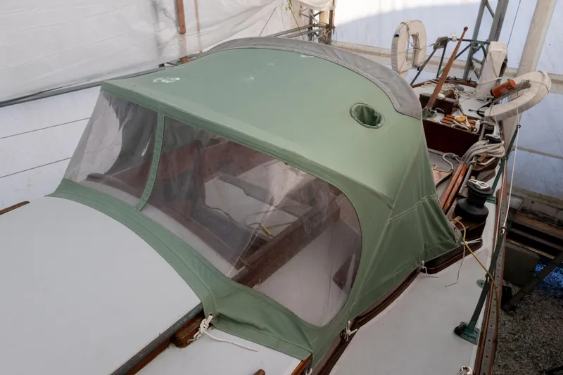 Slide: The Image of 1965 Concordia 39 sailboat with green canvas cover in a sheltered area. - 20
