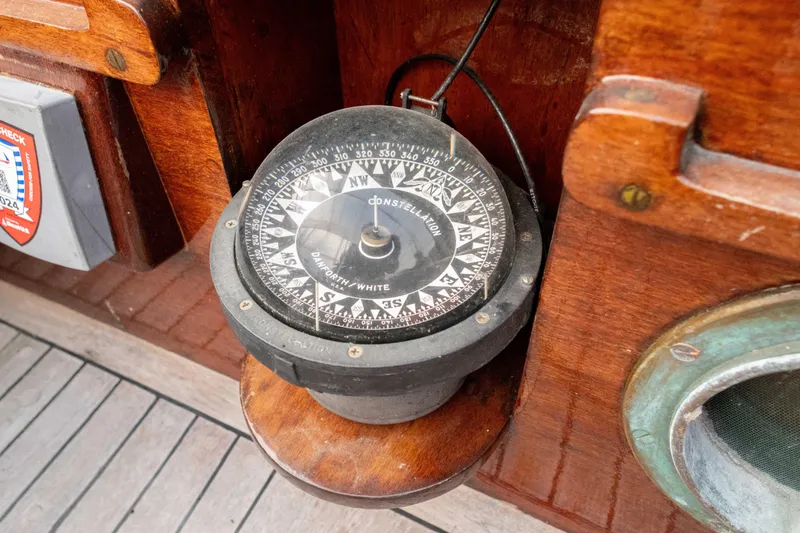 Slide: The Image of Vintage compass on a 1965 Concordia 39 wooden boat deck. - 24
