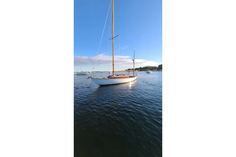 Slide: The Image of Classic 1965 Concordia 39 sailboat on calm water under clear blue sky. - 3