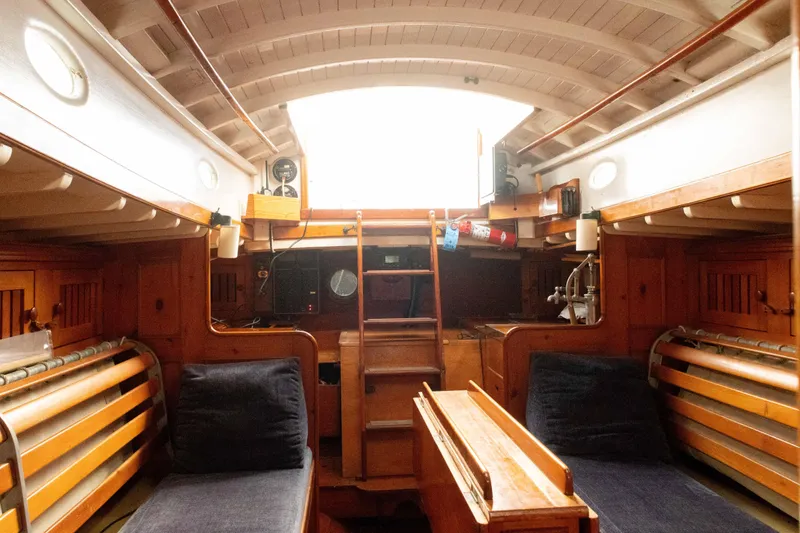 Slide: The Image of Interior of a 1965 Concordia 39 sailboat with wooden furnishings and cozy seating. - 32