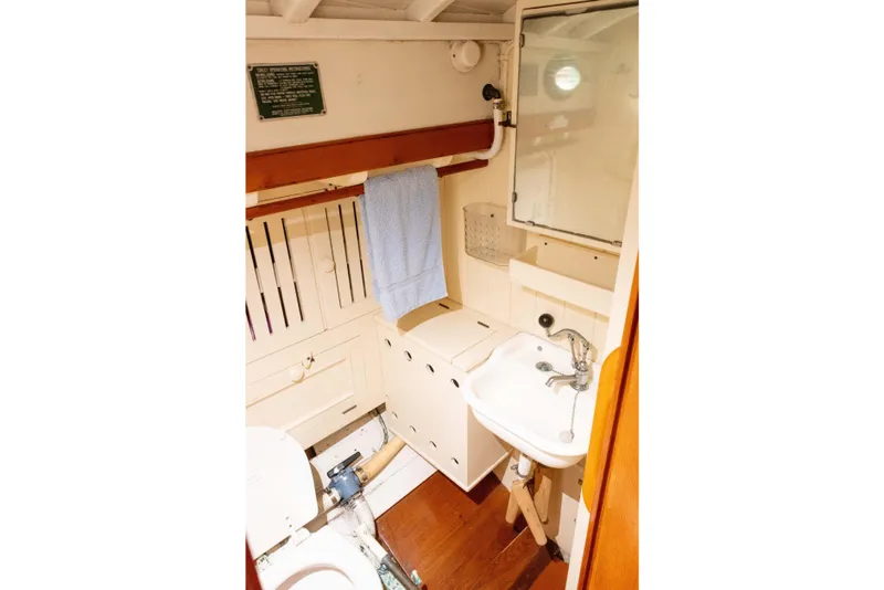 Slide: The Image of Vintage 1965 Concordia 39 yacht bathroom with sink, mirror, and storage cabinets. - 37