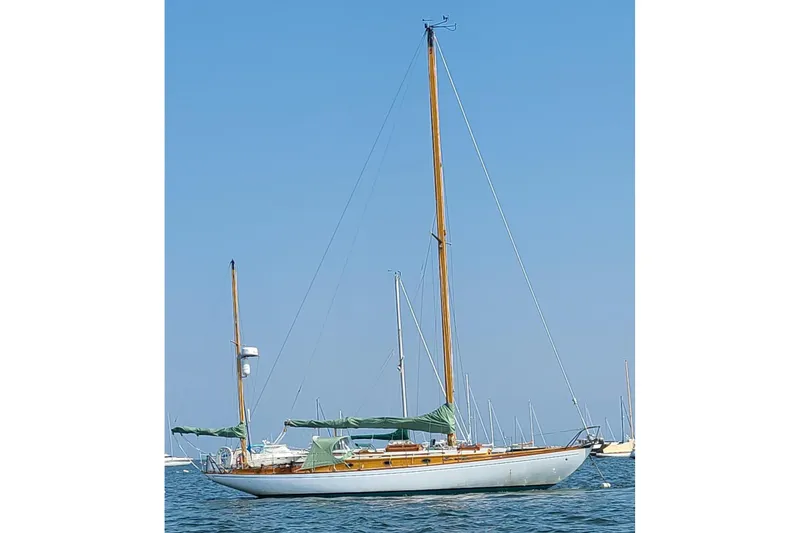 Slide: The Image of Classic 1965 Concordia 39 sailboat on calm water under clear blue sky. - 4