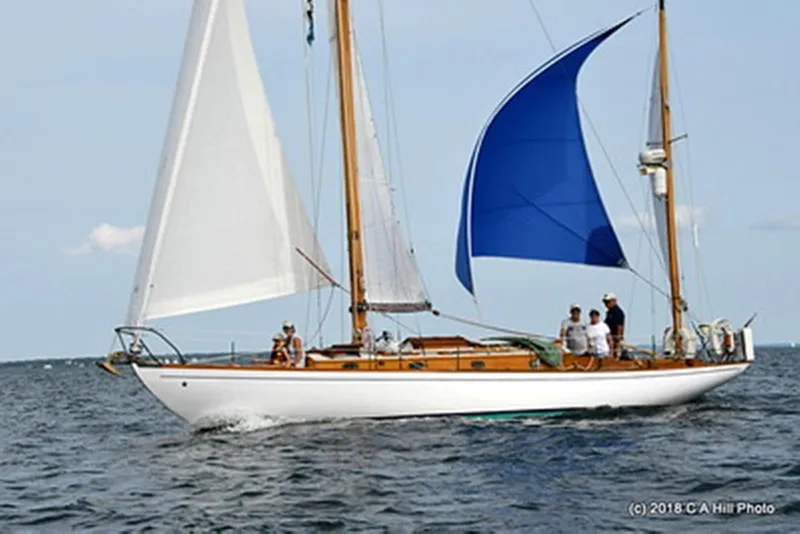 Slide: The Image of 1965 Concordia 39 sailboat with blue and white sails on open water. - 6