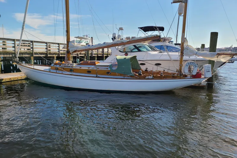 Slide: The Image of Classic 1965 Concordia 39 sailboat docked at a marina, showcasing elegant wooden design. - 7