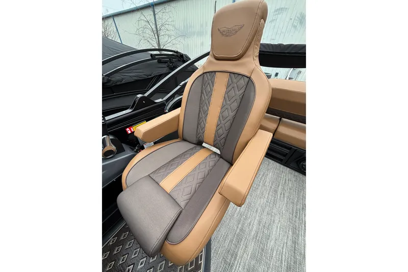 Slide: The Image of Luxurious seating in the 2026 Bennington 22 M Swingback boat, featuring elegant brown and gray upholstery. - 12