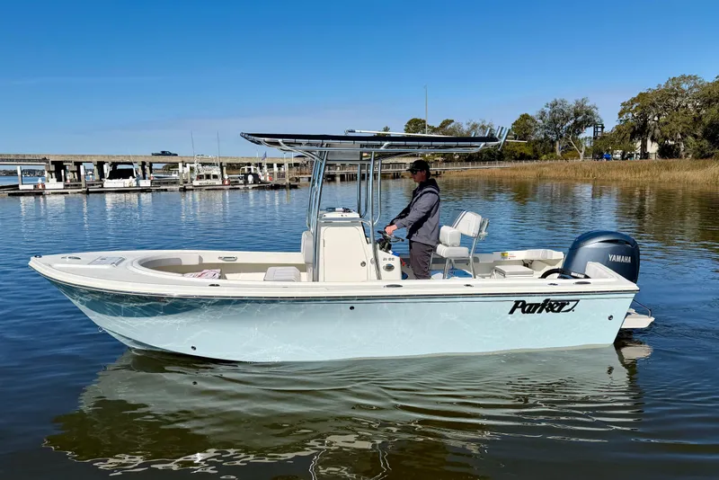 Slide: The Image of 2024 Parker 2100 Special Edition boat on calm water, featuring Yamaha engine. - 0