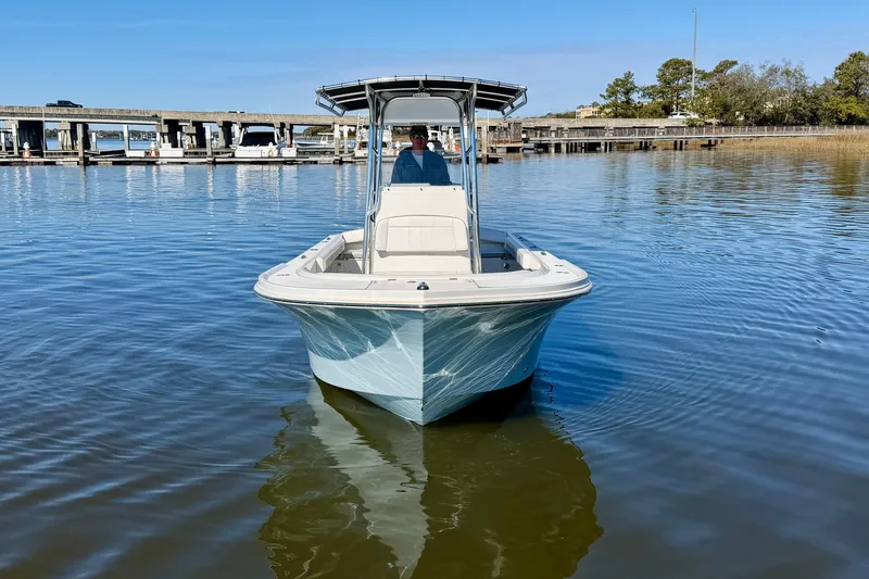 The Image of 2024 Parker 2100 Special Edition boat on calm water near a marina. - 1