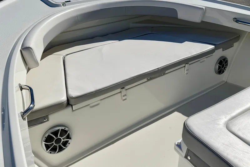 Slide: The Image of 2024 Parker 2100 Special Edition boat interior with cushioned seating and built-in speakers. - 14