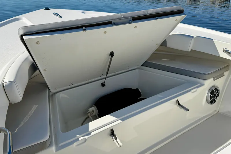Slide: The Image of Open storage compartment on 2024 Parker 2100 Special Edition boat, with seating and speaker. - 18