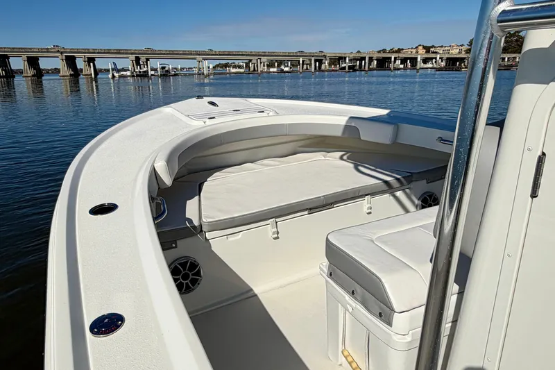 Slide: The Image of 2024 Parker 2100 Special Edition boat interior with seating, on calm water near a bridge. - 32
