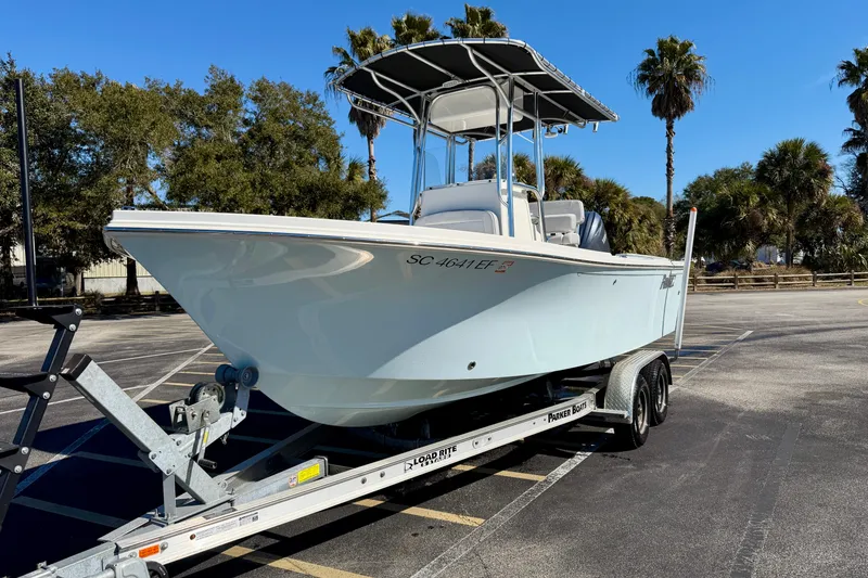 Slide: The Image of 2024 Parker 2100 Special Edition boat on trailer, parked with palm trees in background. - 38