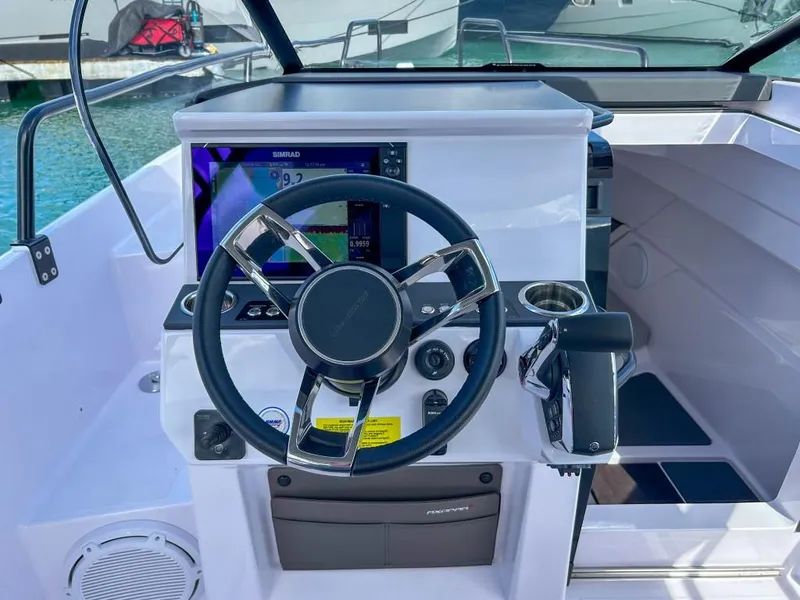 Slide: The Image of 2024 Axopar 25 Cross Top boat helm with steering wheel and navigation display. - 6