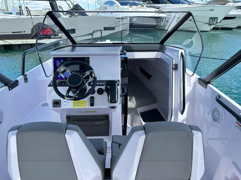 Slide: The Image of 2024 Axopar 25 Cross Top boat interior with steering wheel and seating. - 7